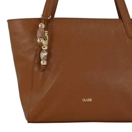 Close frontal inferior da bolsa caramelo mostrando acabamento dourado e textura lisa